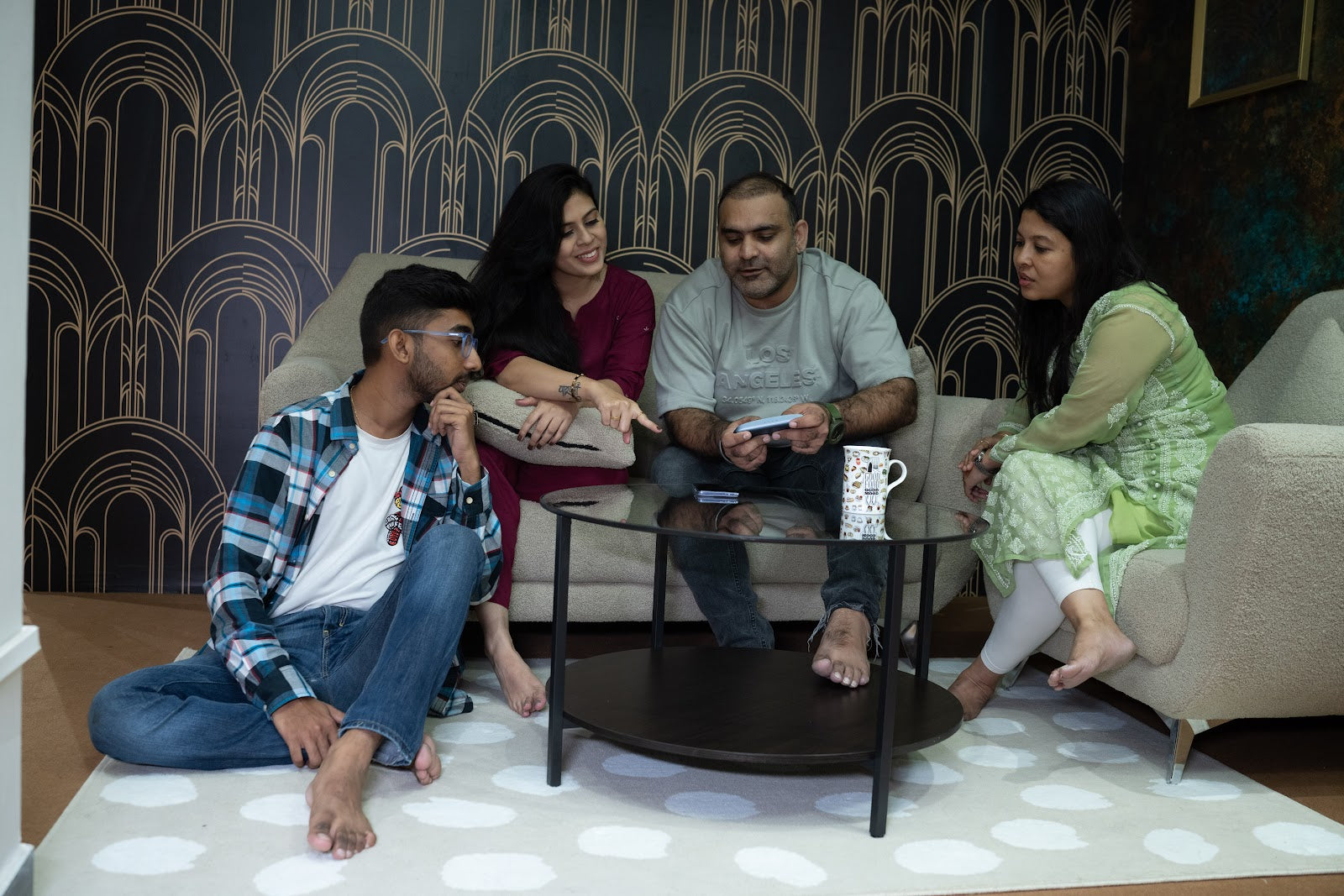 A family of four together on the couch at home, passing the EYVA device between them.