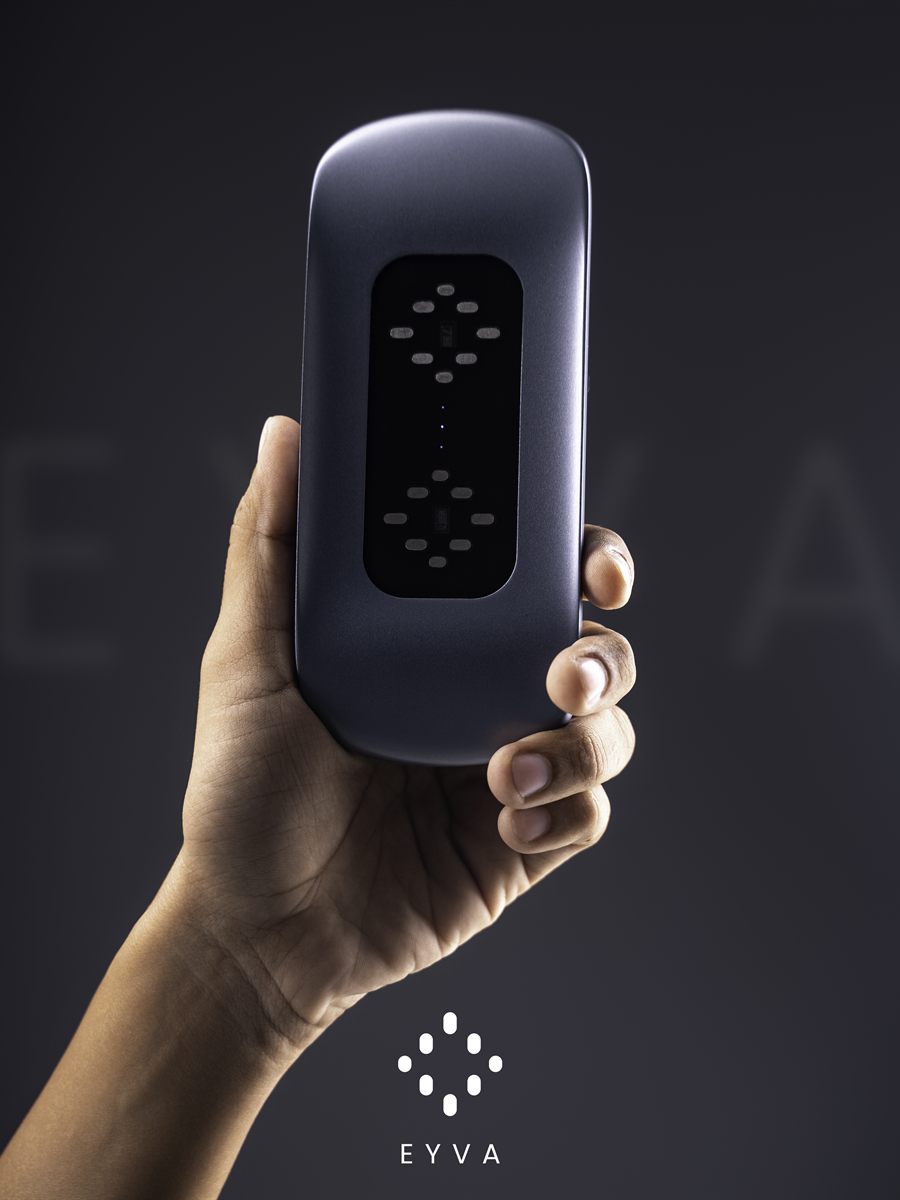 The EYVA device held upright in one hand, its sensor display lit.
