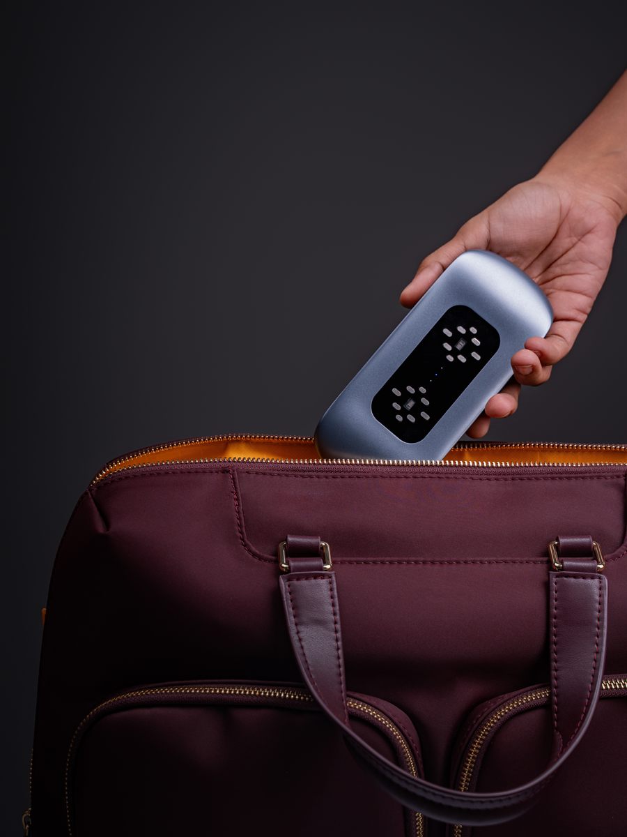 EYVA being placed into an open handbag.